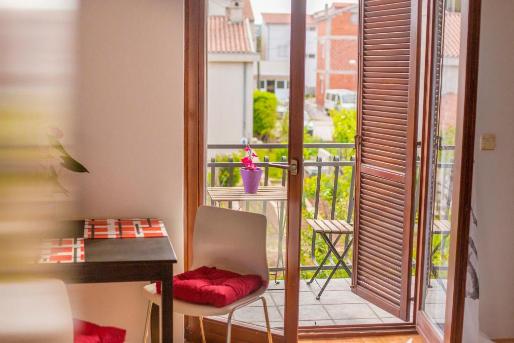 een kamer met een balkon, een bureau en een tafel bij Ava apartmani in Zablaće