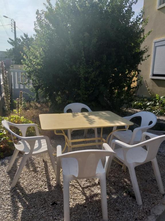 - une table de pique-nique et des chaises en face d'une brousse dans l'établissement appartfa, à La Celle-sous-Gouzon