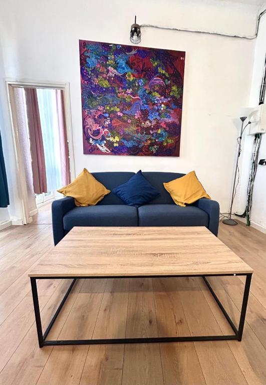 - un canapé bleu dans le salon orné d'un tableau dans l'établissement Central Charmant T2 4P Meublé et équipé Cours Julien Marseille, à Marseille