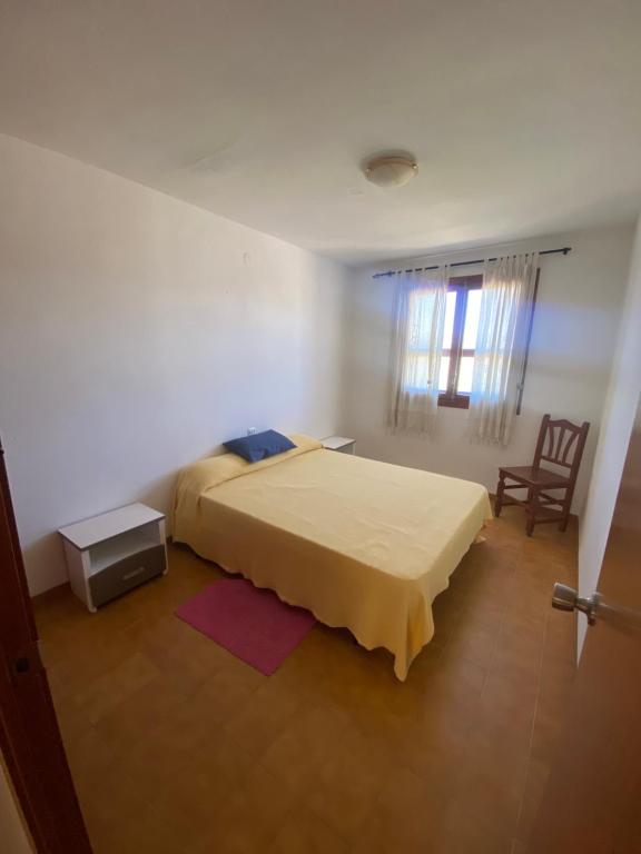 Un dormitorio con una cama, una mesa y una silla. en Caseta Ana, en La Estación