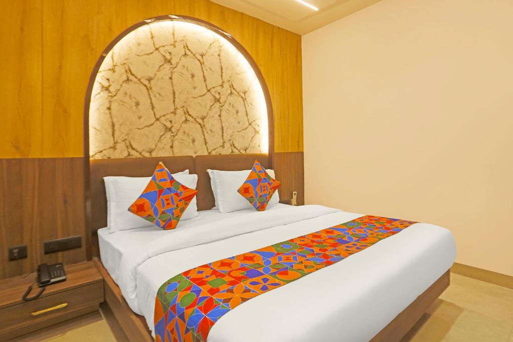 a bedroom with a large bed with a colorful blanket at FabHotel Mishika Inn Near New Delhi Railway Station in New Delhi