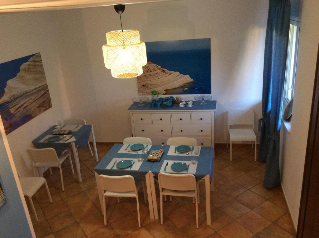 jadalnia z niebieskim stołem i krzesłami w obiekcie B&B in Residence "...a due passi dalla Scala dei Turchi" w mieście Porto Empedocle
