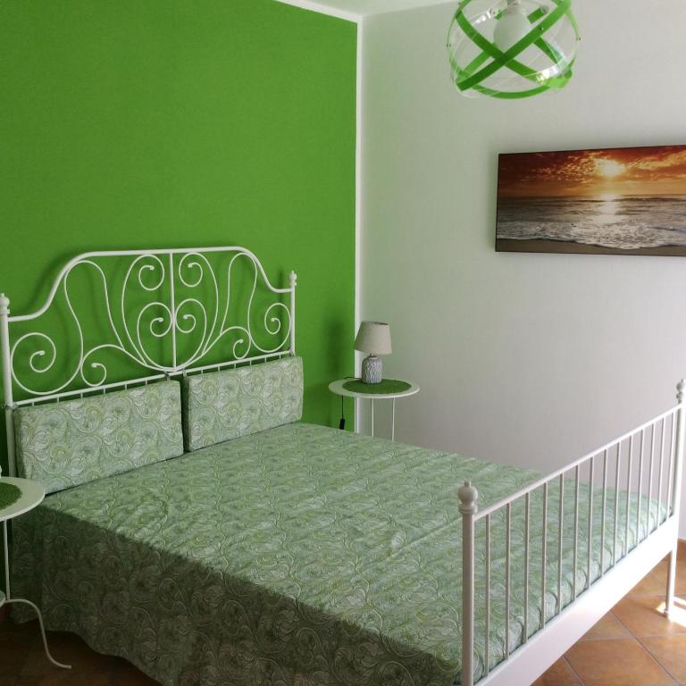 una camera da letto con un letto con una parete verde di B&B in Residence "...a due passi dalla Scala dei Turchi" a Porto Empedocle