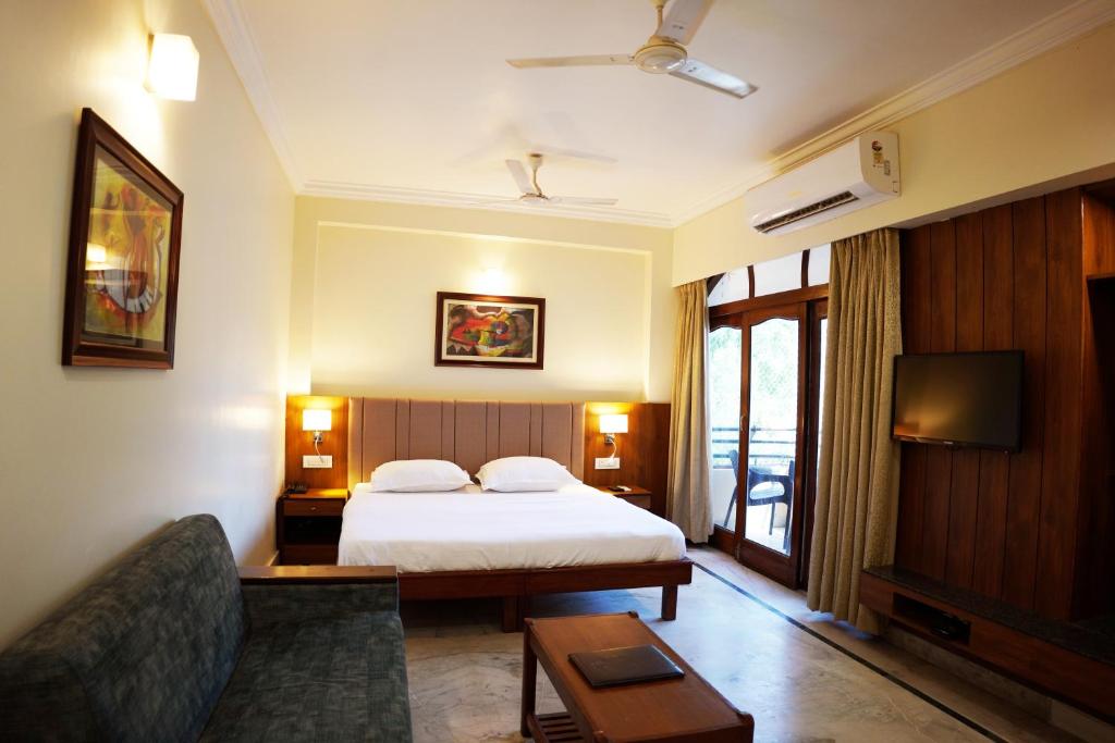 a hotel room with a bed and a couch at hotel sandhu palace in Jodhpur