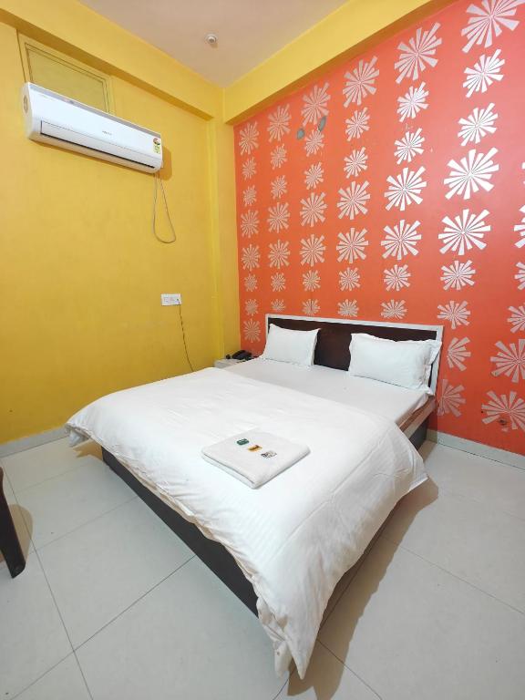 a bedroom with a large bed with a white blanket at Hotel Pink City in Sīkar
