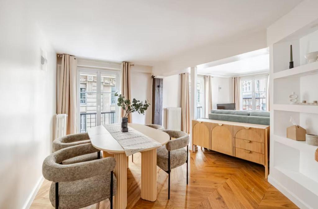 un salon avec une table et des chaises et un lit dans l'établissement Luxury Living in Paris 1er - Palais Royal, Victoires-louvre, à Paris
