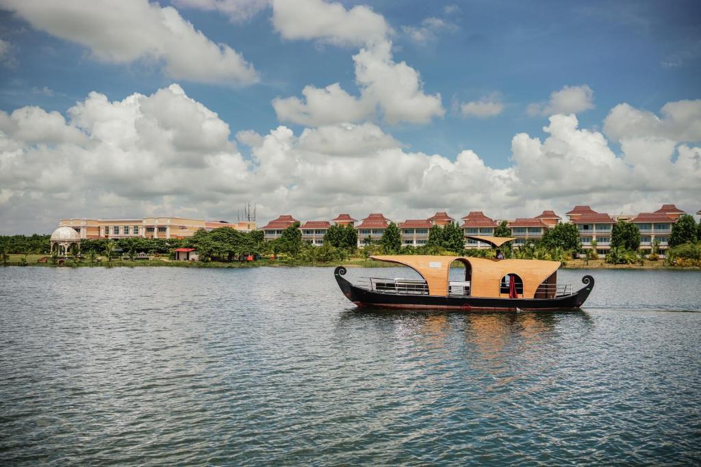 a boat on the water in front of a building at MAYFAIR Lake Resort in Raipur