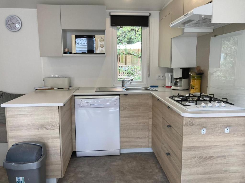 a kitchen with a sink and a stove top oven at Le Domaine des Pins in Saint-Hilaire-de-Riez