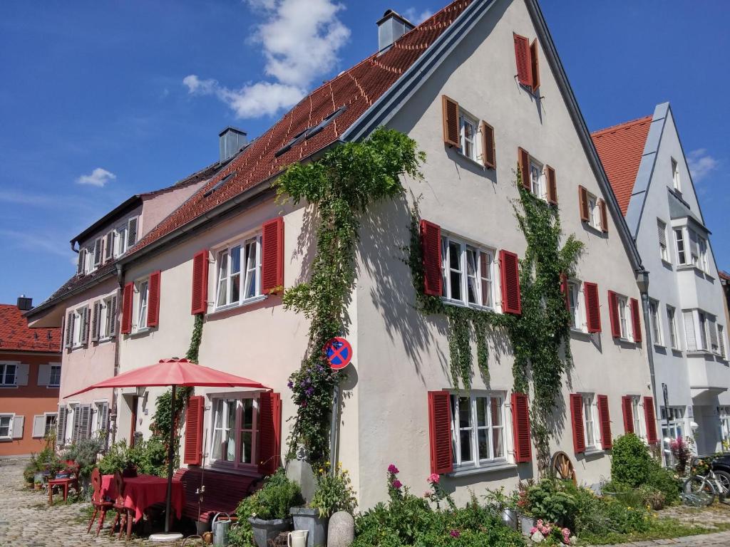 ein weißes Gebäude mit roten Fensterläden und Efeu drauf. in der Unterkunft Zweite Heimat Privatpension in Landsberg am Lech