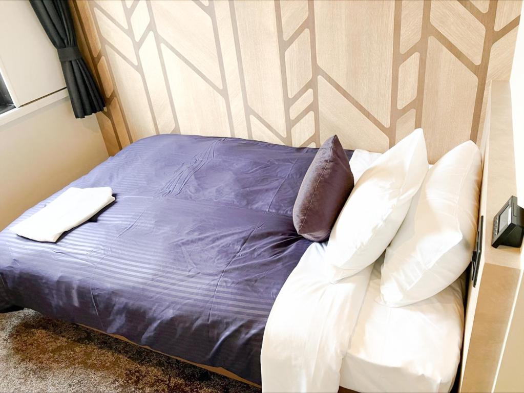 Postel nebo postele na pokoji v ubytování HOTEL LiVEMAX BUDGET Sagamihara