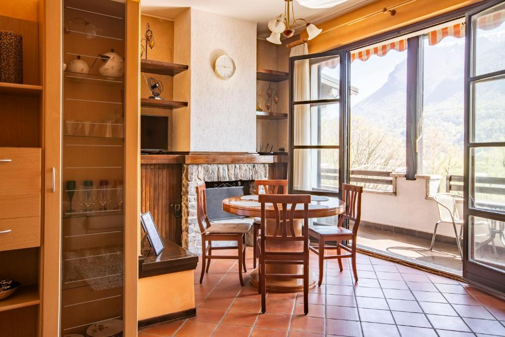 une cuisine avec une table et des chaises ainsi qu'une cheminée dans l'établissement La Dimora del Tasso - Garden, Terrace & Mountain View, à Carlazzo