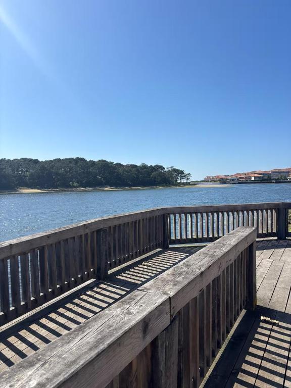 une jetée en bois avec vue sur l'eau dans l'établissement Appart proche du lac et plages, à Soustons