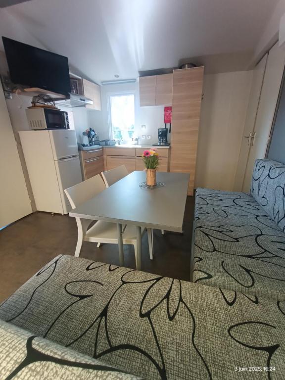 a small room with a table and a kitchen at Camping les sablines 129 à vendres-plage in Vendres