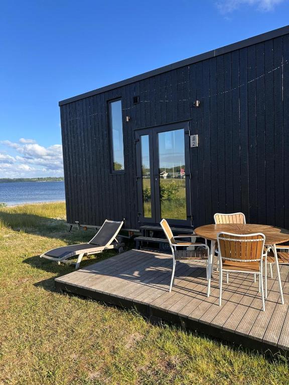 LillekobbelTiny SeaSide - Loddenhøj的黑色的小房子,甲板上配有桌椅