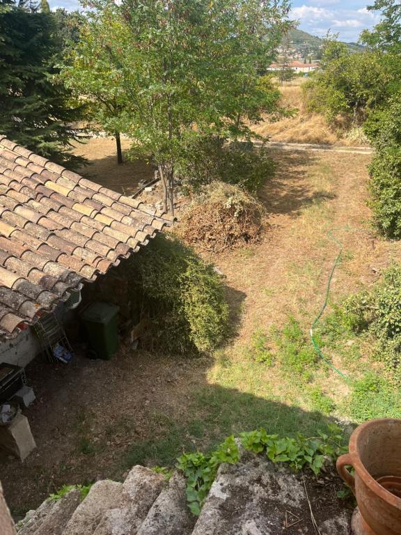 un toit en pierre d'une maison avec un arbre dans l'établissement Grenier de la Chimère, à Manosque