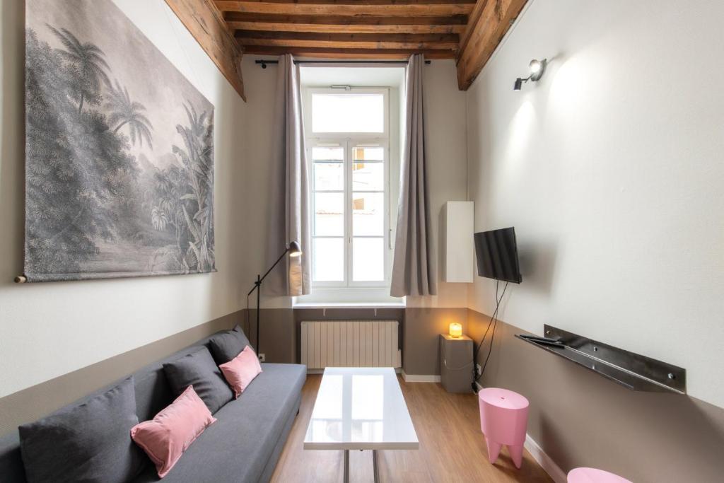 un salon avec un canapé et une table dans l'établissement Caponni, à Lyon