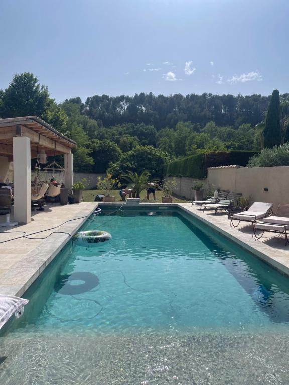 une piscine avec de l'eau bleue dans une cour arrière dans l'établissement Belle bastide provençale, à Noves