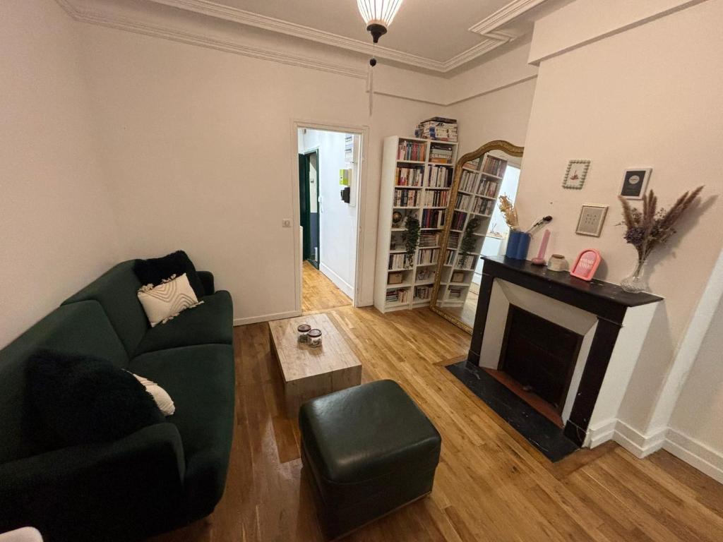 - un salon avec un canapé vert et une cheminée dans l'établissement Appartement cosy, à Ivry-sur-Seine