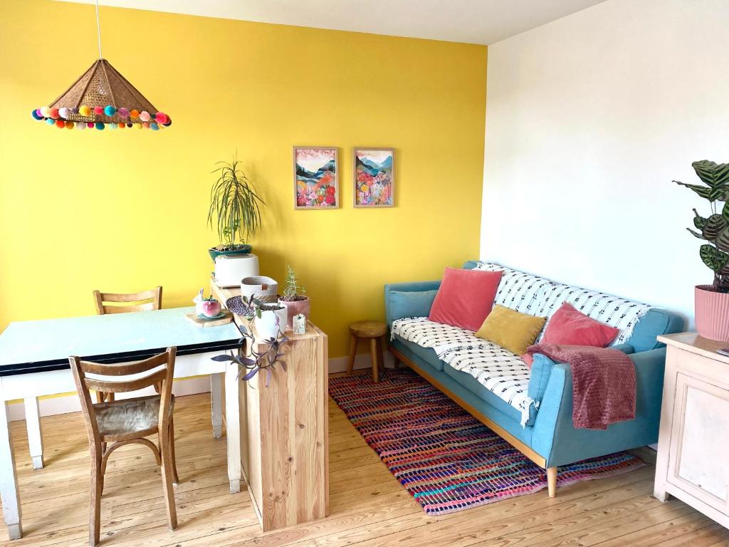 un salon avec un canapé bleu et une table dans l'établissement Inspired space, au Mans