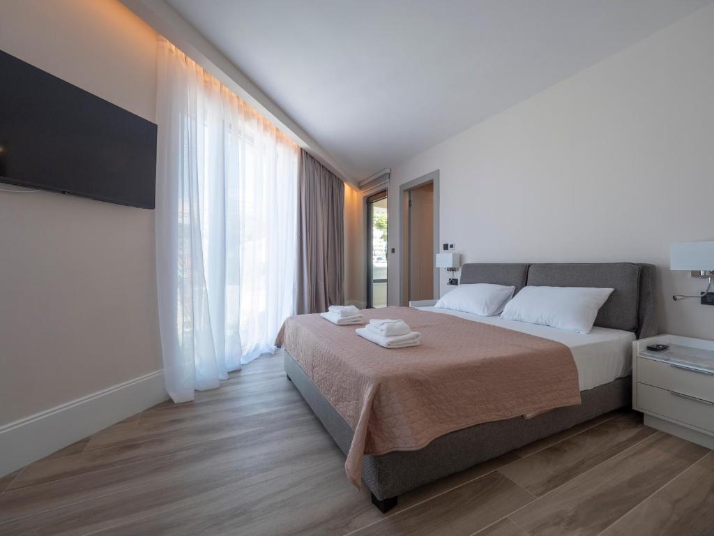 a bedroom with a bed and a large window at CASA AL MARE RESIDENCE in Bečići