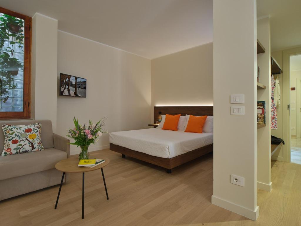 a bedroom with a bed and a couch and a table at Portica Homes Assisi in Assisi