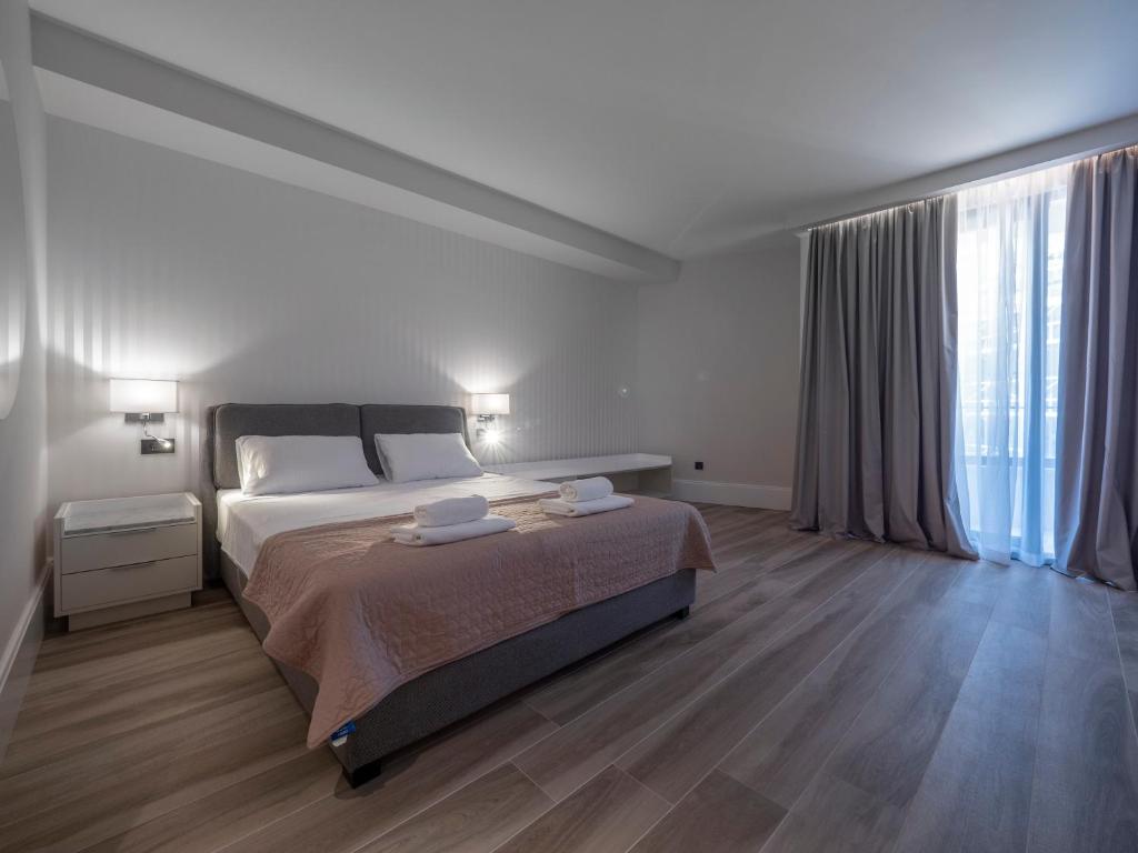 a bedroom with a large bed and a large window at CASA AL MARE RESIDENCE in Bečići