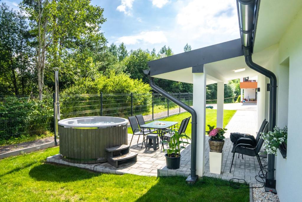 a patio with a hot tub and a table and chairs at Chata Kotva White House in Trstená