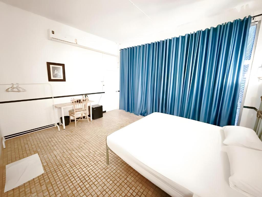 a hotel room with a bed and a table at Toss Inn Hat Yai - ทอส อิน หาดใหญ่ in Hat Yai