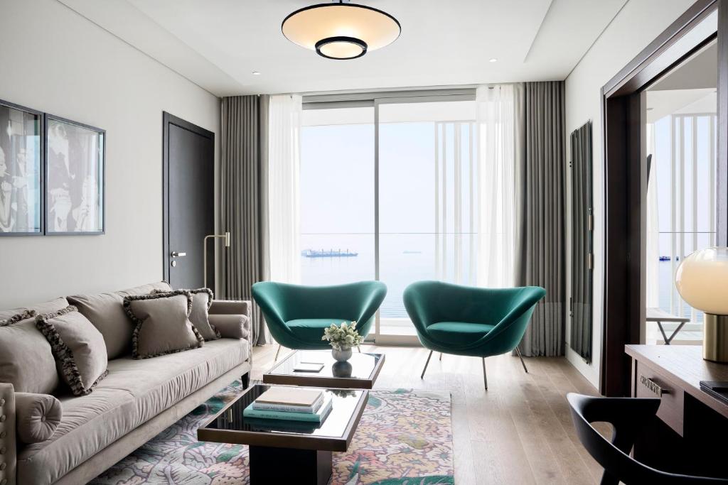 a living room with a couch and two green chairs at ON Residence - Small Luxury Hotels of the World in Thessaloniki