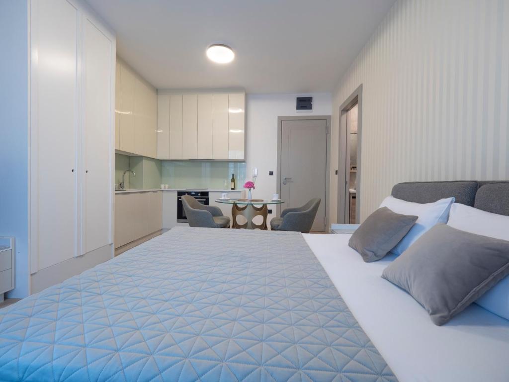 a bedroom with a large bed and a kitchen at CASA AL MARE RESIDENCE in Bečići