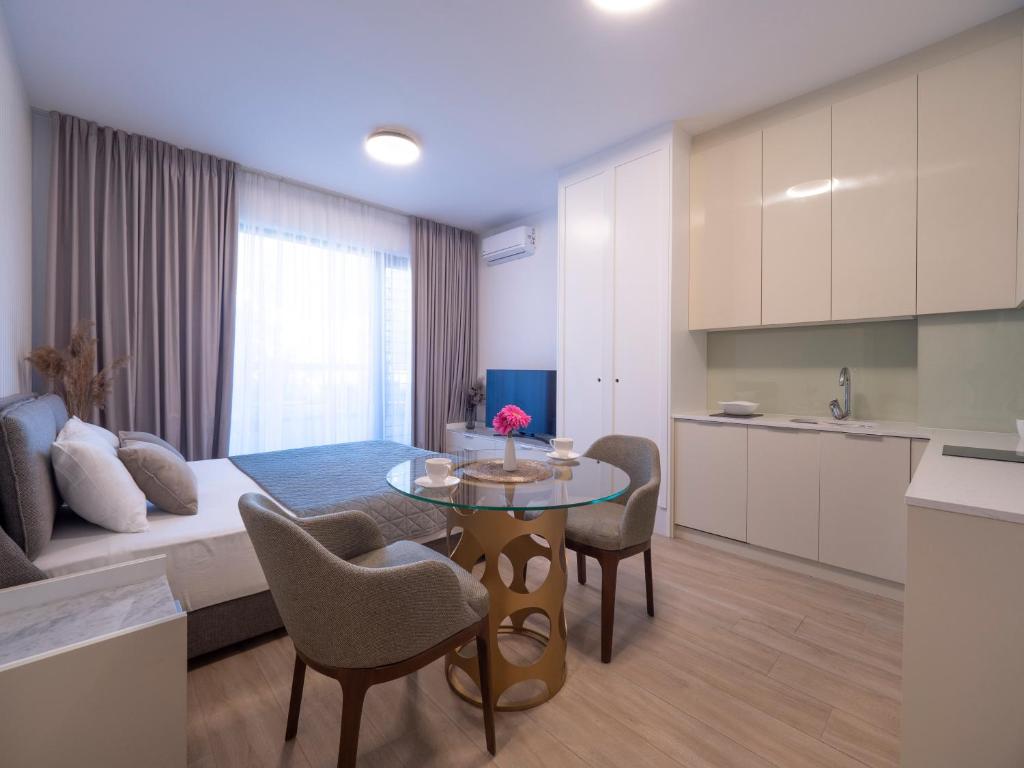 a living room and kitchen with a table and chairs at CASA AL MARE RESIDENCE in Bečići