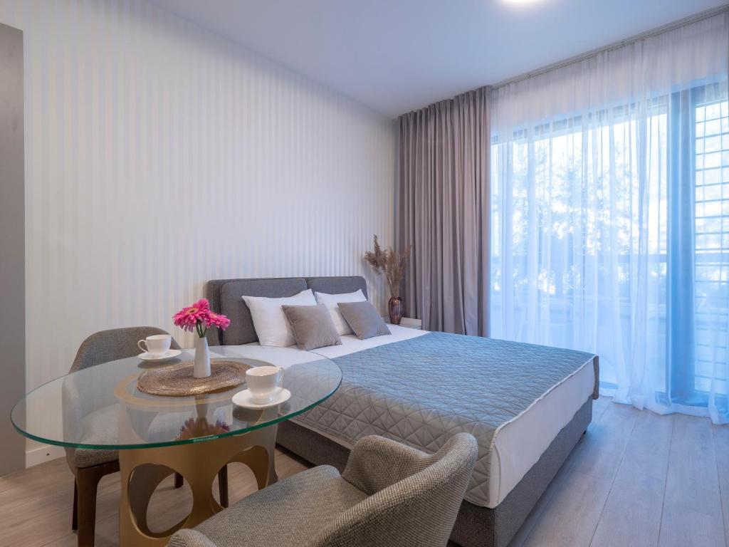 a bedroom with a bed and a glass table at CASA AL MARE RESIDENCE in Bečići