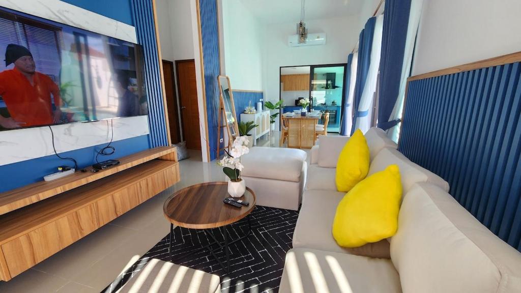 a living room with a white couch and yellow pillows at 2B2B Pool villa Near Big buddha,Soi TaEid,BCIS Phuket in Ban Klang