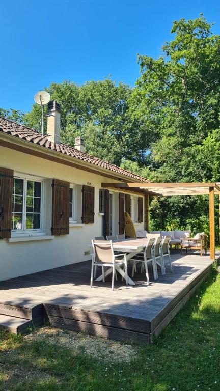 un patio avec une table et des chaises devant une maison dans l'établissement Maison Confortable en forêt près des plages Aucun voisinage, à Saint-Pierre-dʼOléron