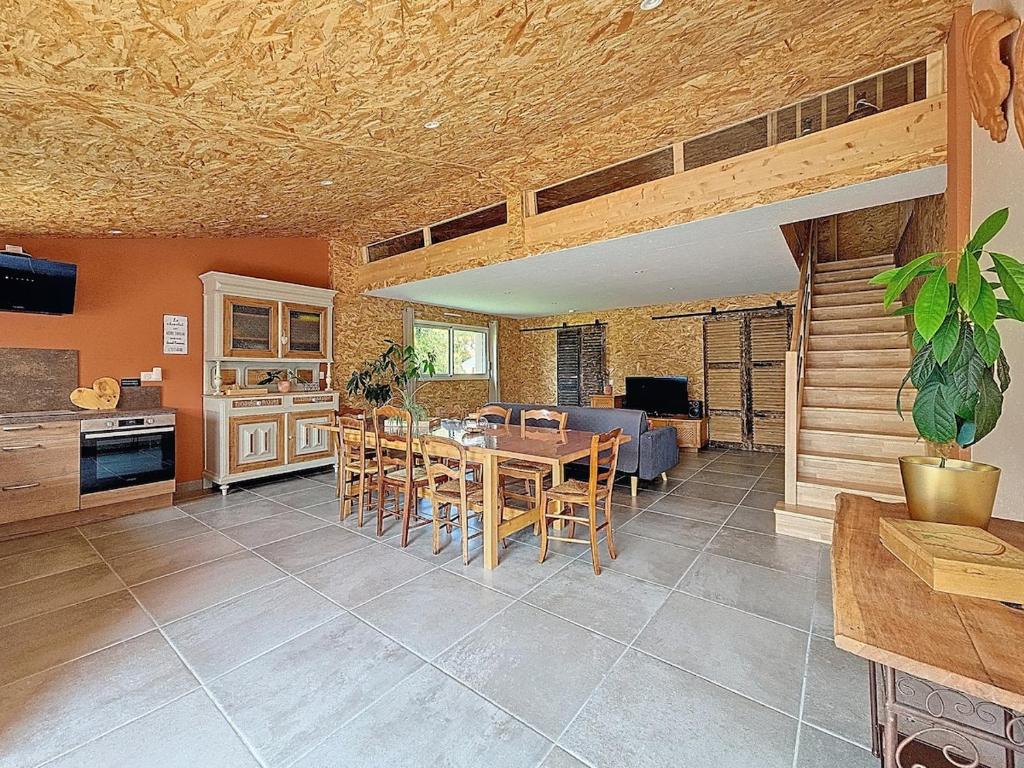 une cuisine et une salle à manger avec une table et des chaises dans l'établissement Bienvenue à l'Atelier !, à Landemont
