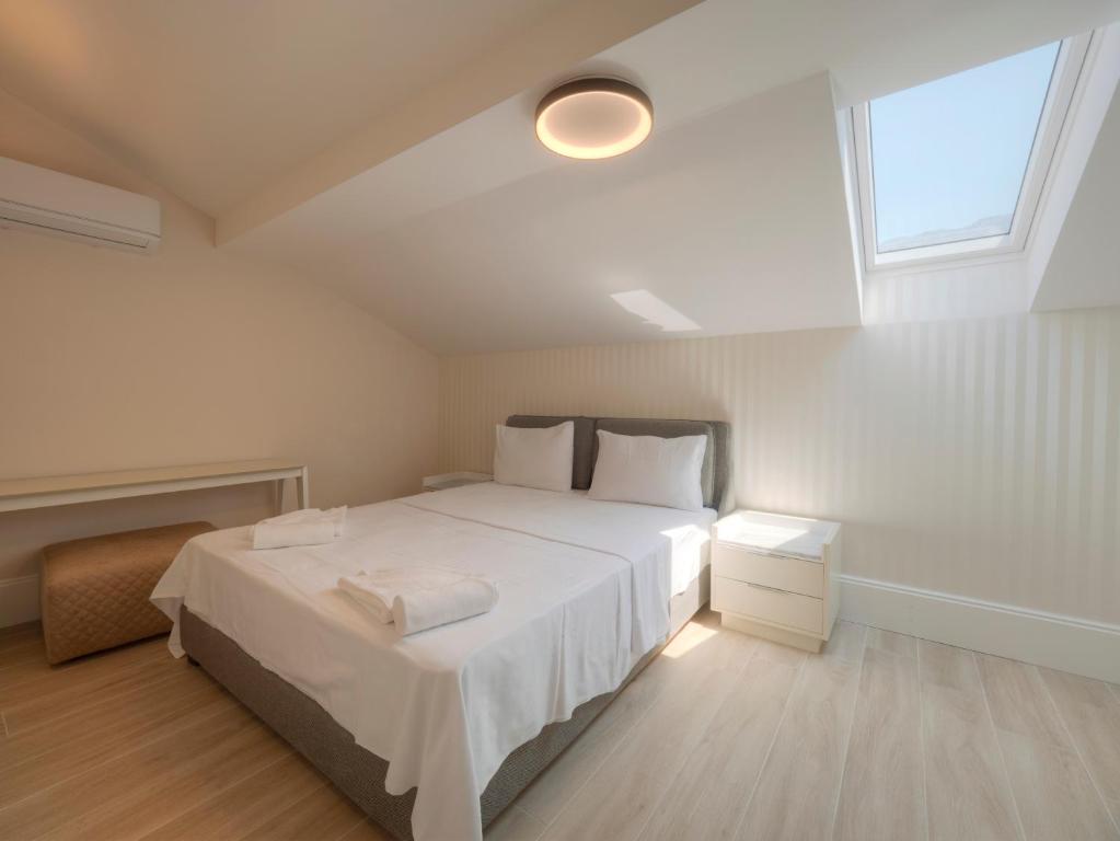 a bedroom with a large white bed and a window at CASA AL MARE RESIDENCE in Bečići
