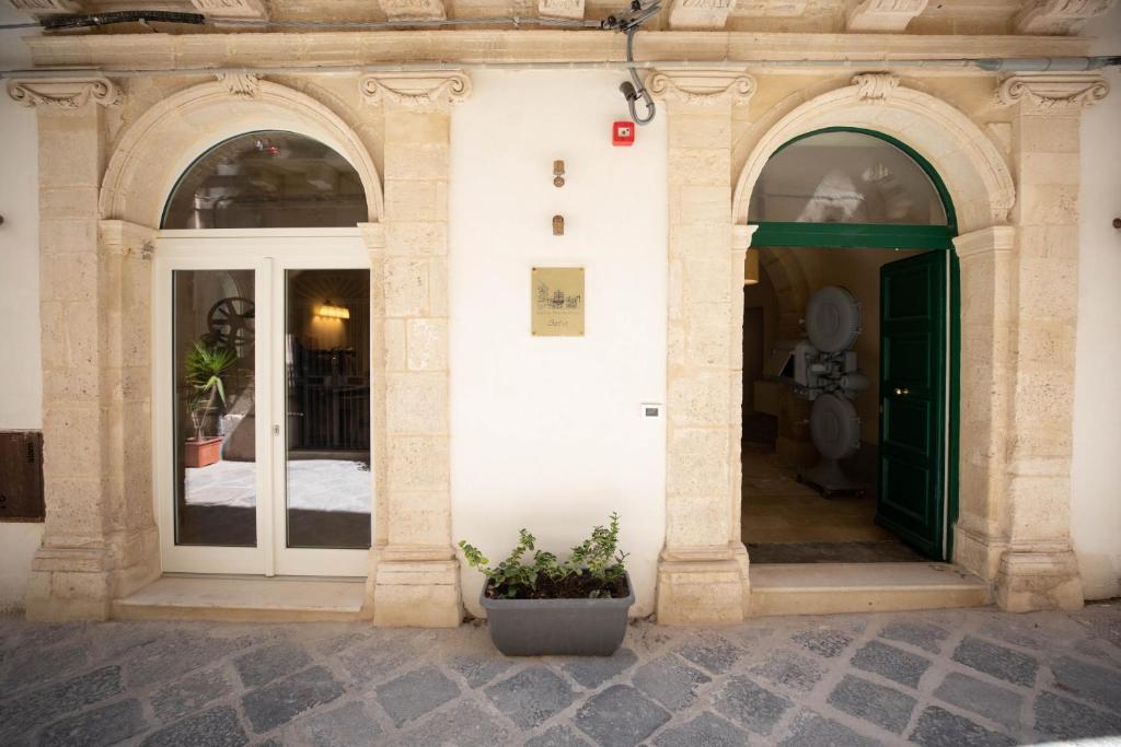 Postel nebo postele na pokoji v ubytování Lanterne Magiche Ortigia Suites