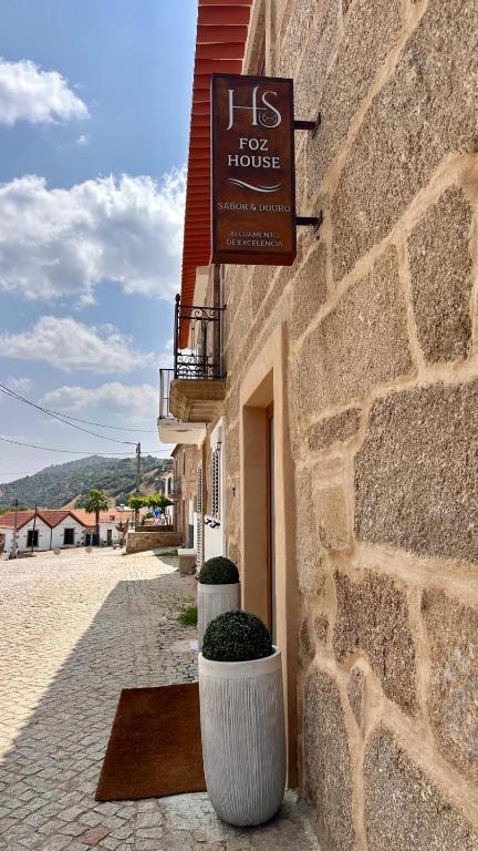 a building with two large pots in front of a building at Foz House Sabor & Douro in Torre de Moncorvo