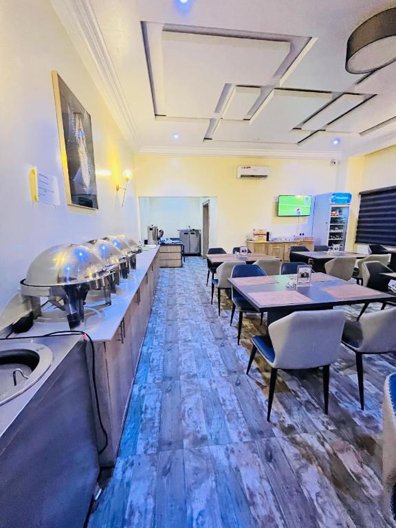 a restaurant with tables and chairs in a room at Global Suites in Kano