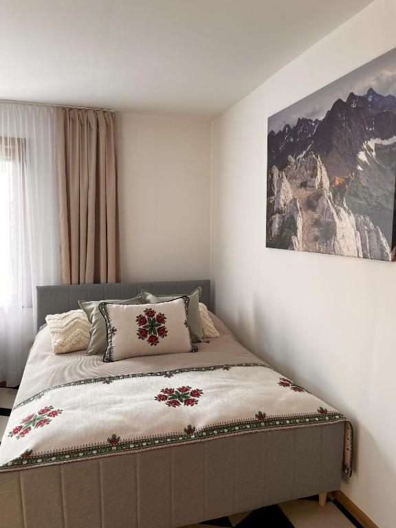 a bedroom with a bed with a picture on the wall at Antoniówka in Zakopane