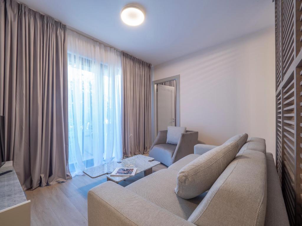 a living room with a couch and a chair at CASA AL MARE RESIDENCE in Bečići