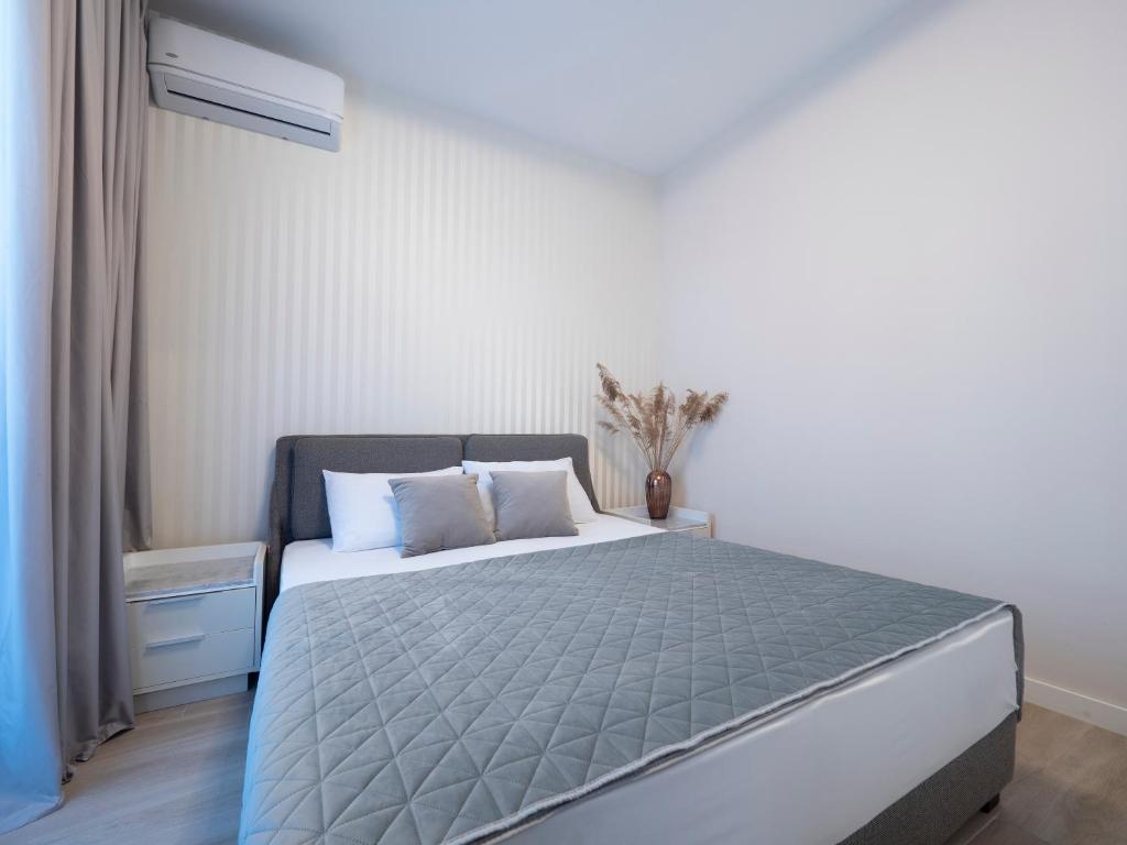 a bedroom with a bed with a gray comforter at CASA AL MARE RESIDENCE in Bečići