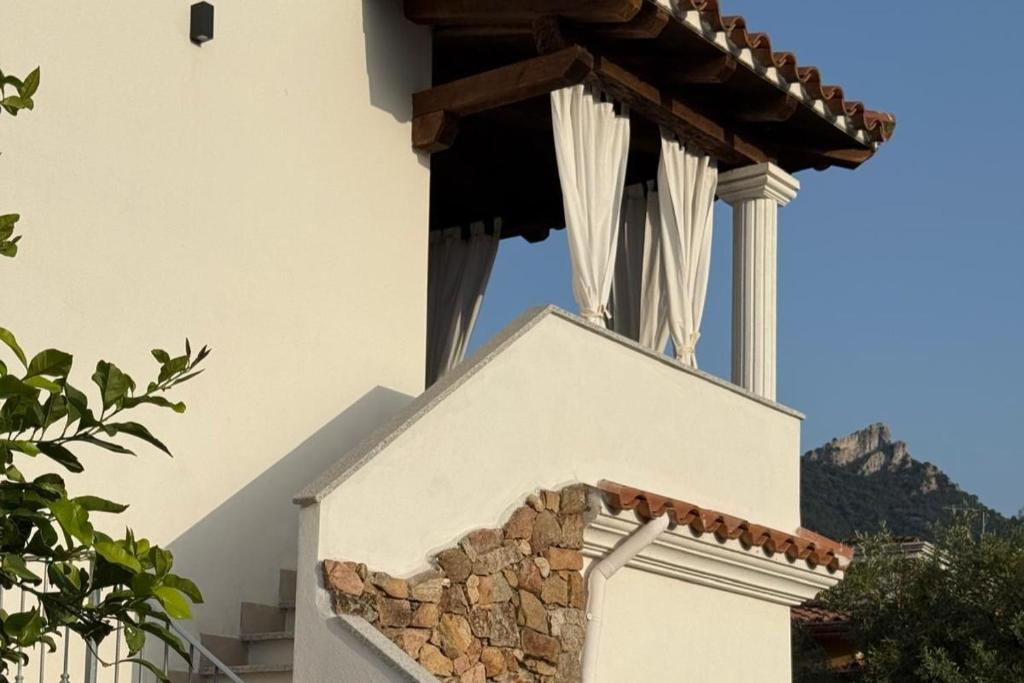 a white building with a fireplace on top of it at CasaNica - Elegant independent apartment in Torpè