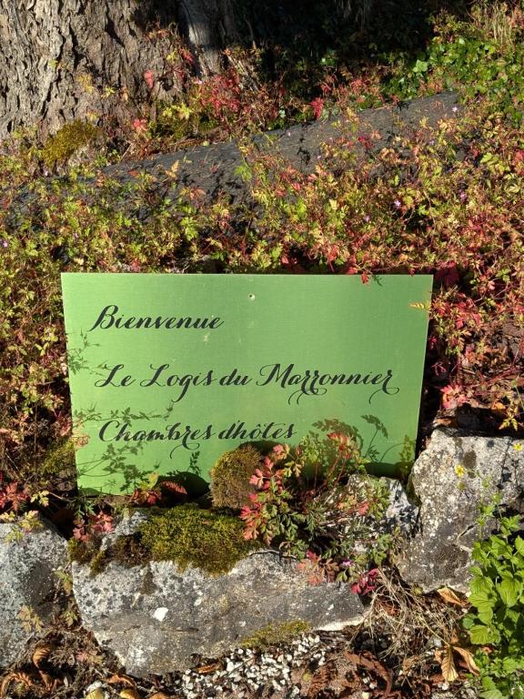 un panneau sur des rochers avec une écriture dessus dans l'établissement Le Logis du Marronnier, à Perpezac-le-Noir