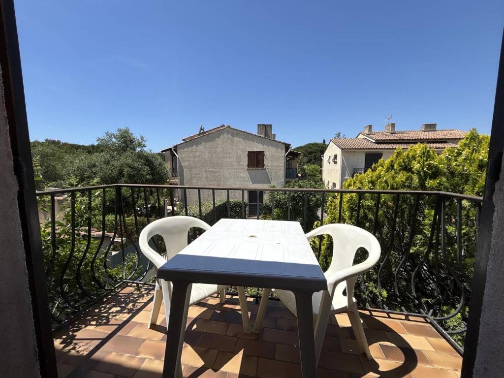 une table et deux chaises sur un balcon dans l'établissement Appartement Studio 1 couchages La Londe Les Maures LAL240-033, à La Londe-les-Maures