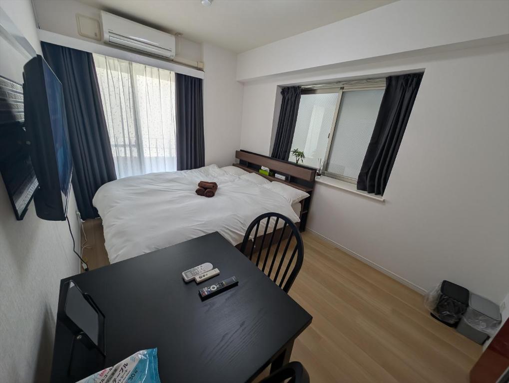 a small room with a bed and a table at MerisuKabukicho,Tokyo in Tokyo