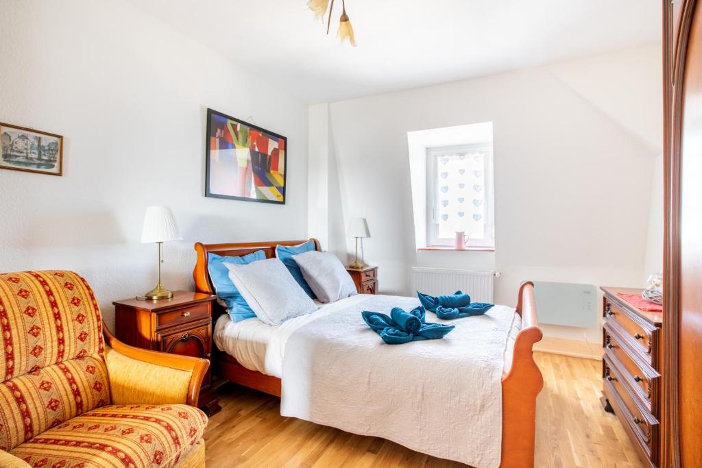 een slaapkamer met een bed en een stoel bij GANZALIESELE in Colmar