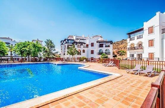 a swimming pool in front of some buildings at El Valle Golf Resort in Baños y Mendigo
