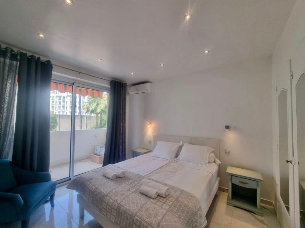 une chambre avec un grand lit et une fenêtre dans l'établissement Appartement Le Bosquet Martinez à Cannes, à Cannes