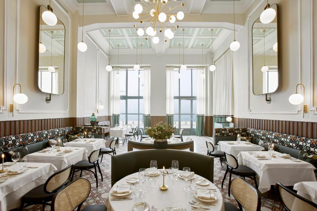a restaurant with white tables and chairs and a chandelier at ON Residence - Small Luxury Hotels of the World in Thessaloniki